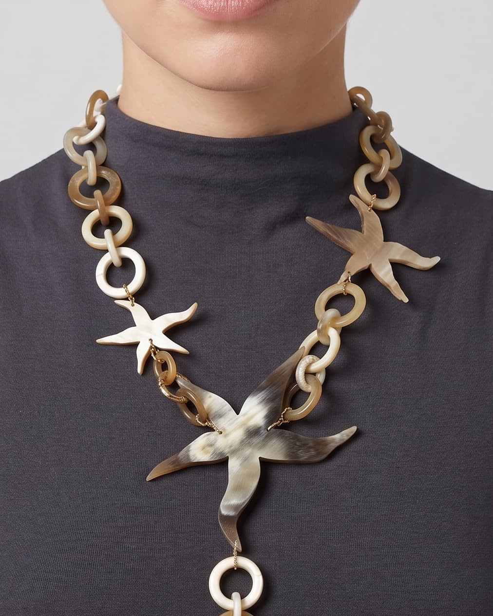 Primer plano de mujer luciendo el collar Marine Star, resaltando la estructura de estrellas de cuerno sobre el cuello.