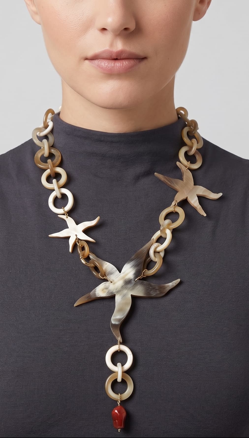 Primer plano de mujer luciendo el collar Marine Star, resaltando la estructura de estrellas de cuerno sobre el cuello.