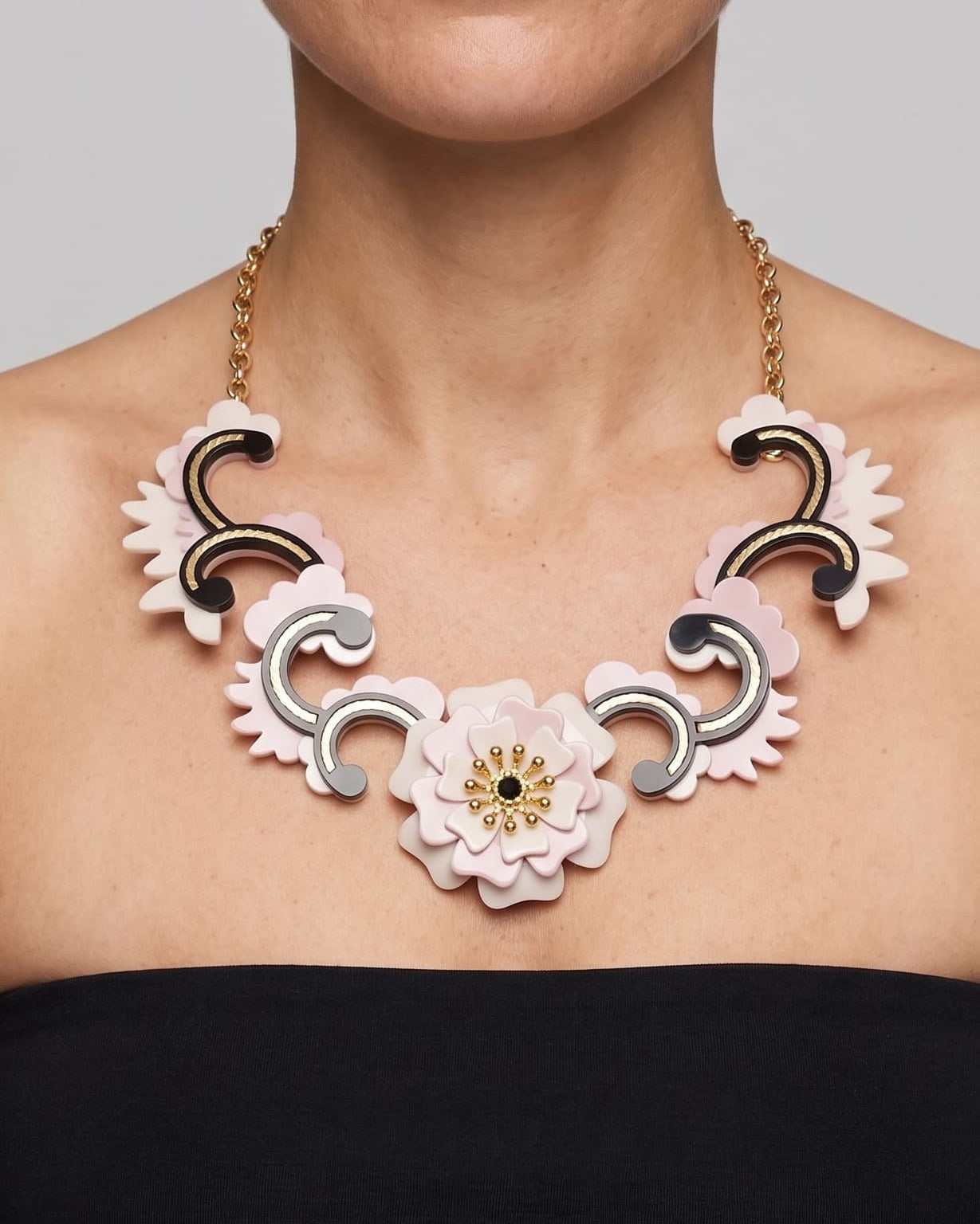modelo luciendo el collar de acrílico de Gissa Bicalho sobre el cuello, destacando su caída, su gran tamaño decorativo y la armonía de sus formas geométricas sobre la piel.