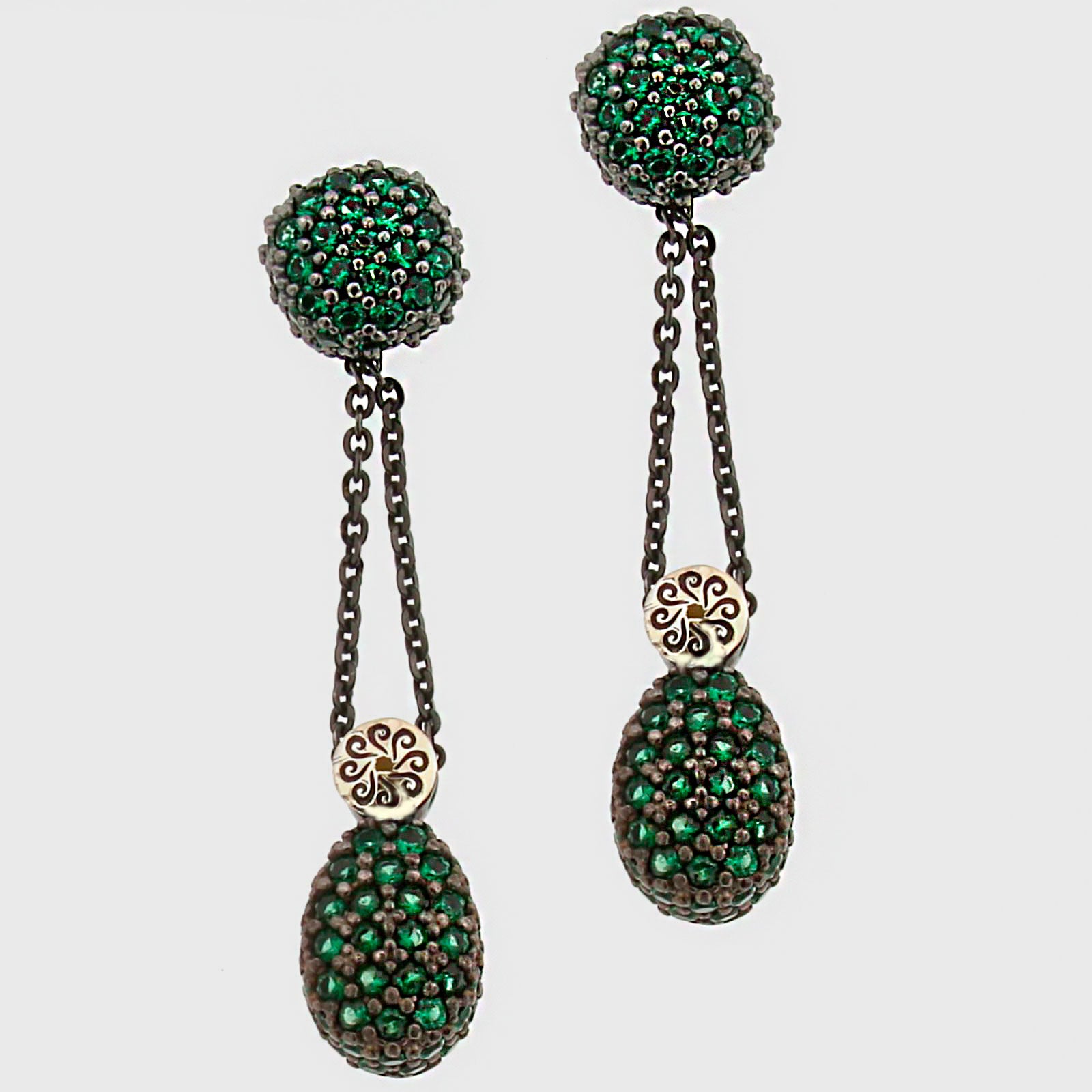 Pareja de pendientes largos Bohemme con esferas de circonitas verdes y cadenas de plata oxidada sobre fondo blanco.