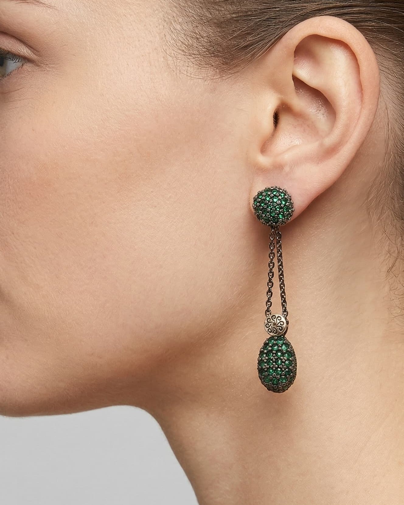 Mujer luciendo los pendientes largos Bohemme verdes, destacando su caída elegante y el brillo de las gemas.