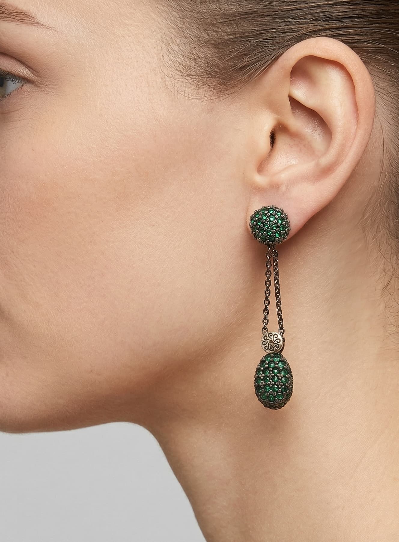 Mujer luciendo los pendientes largos Bohemme verdes, destacando su caída elegante y el brillo de las gemas.