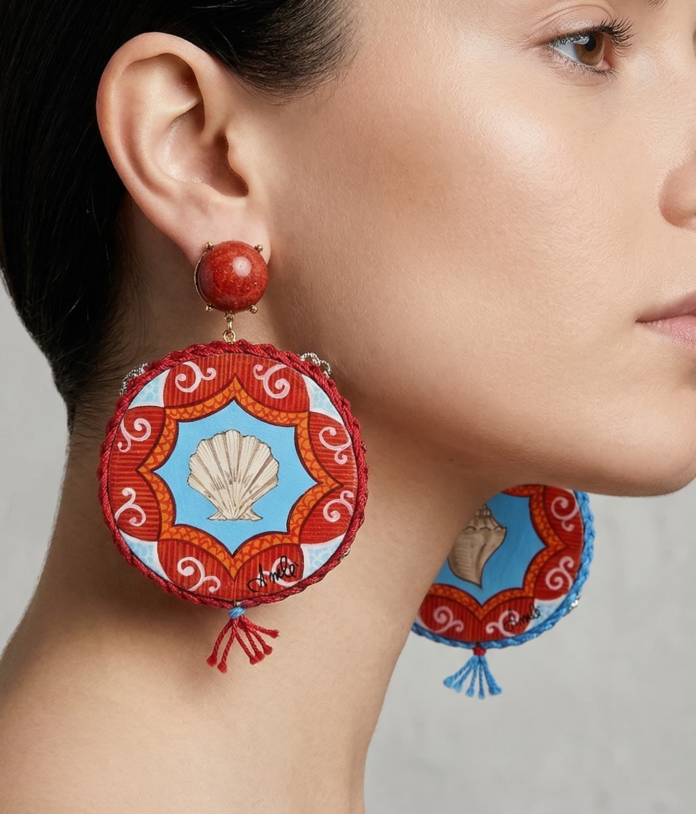 Mujer luciendo los maxi pendientes Amlé Tamburello, destacando el gran tamaño y el colorido artesanal de inspiración italiana.