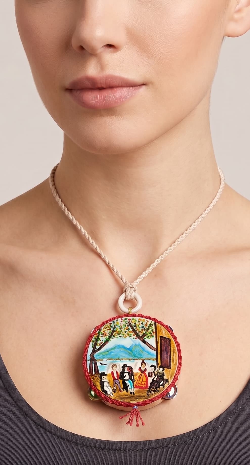 Mujer usando collar artístico Amlé con escena tradicional pintada.