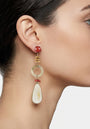 Mujer luciendo los pendientes maxi Amlé, resaltando la caída elegante de los materiales naturales y los tonos tierra.