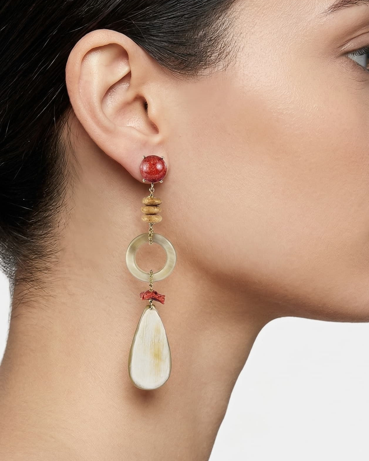 Mujer luciendo los pendientes maxi Amlé, resaltando la caída elegante de los materiales naturales y los tonos tierra.