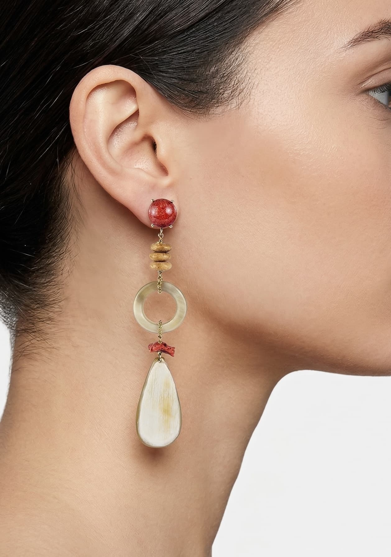 Mujer luciendo los pendientes maxi Amlé, resaltando la caída elegante de los materiales naturales y los tonos tierra.