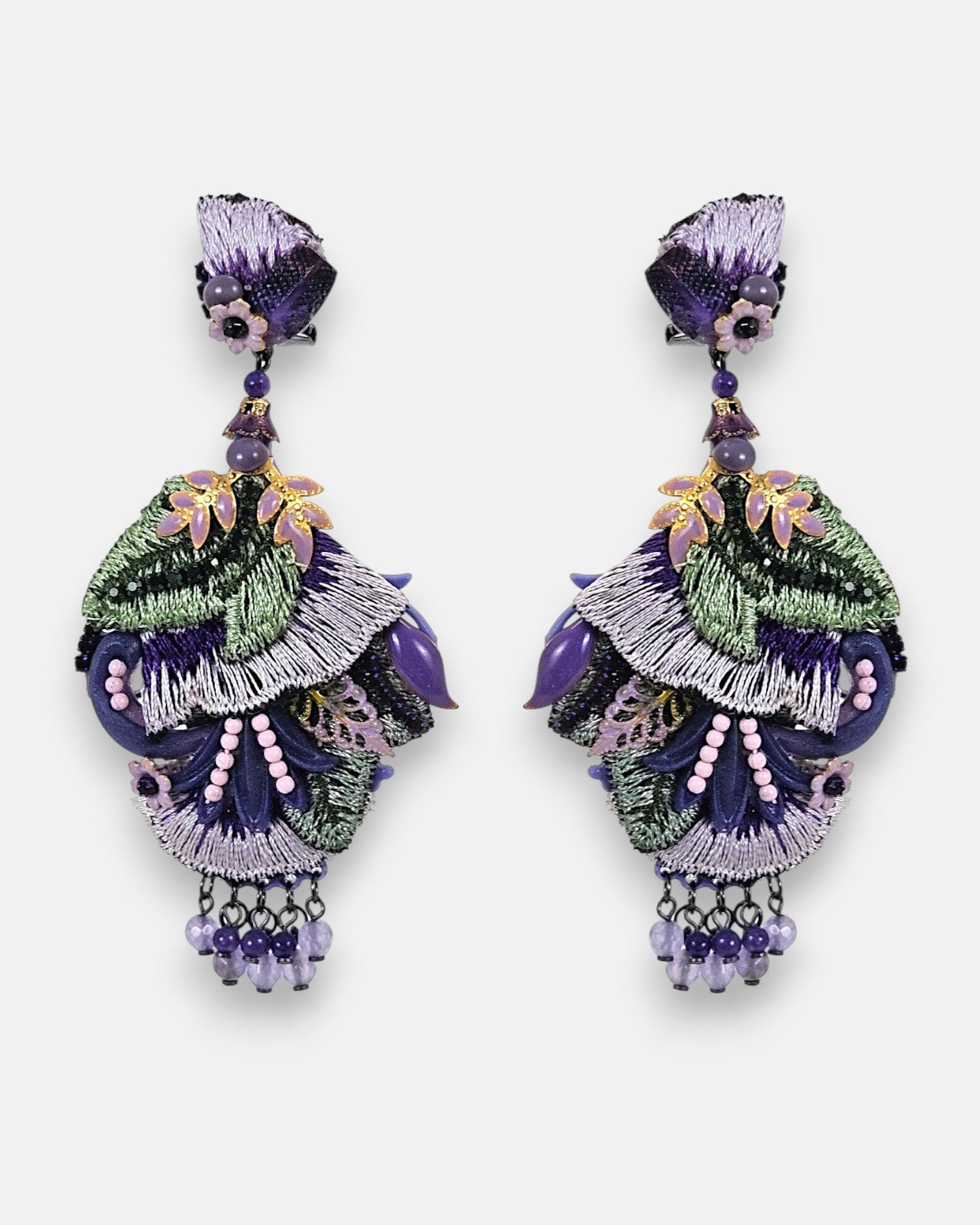 Pareja de pendientes maxi Dublos con bordado de seda en violeta y verde, decorados con hojas lila y pedrería sobre fondo gris claro.