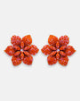 Pareja de pendientes de botón grandes en forma de flor naranja mandarina de la firma Dublos, mostrando su relieve de pétalos y el brillo de sus cristales iridiscentes.