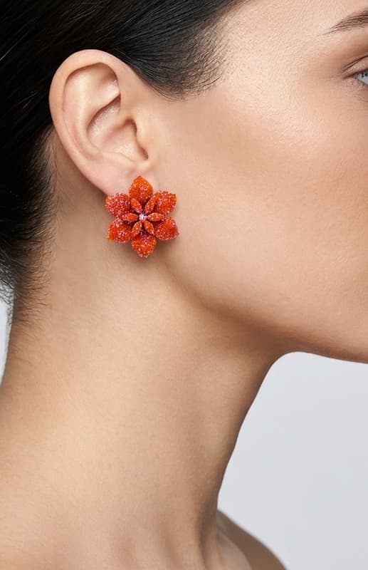 Vista de un maxipendiente de botón Flor de Caléndula colocado en la oreja de una modelo, detallando su volumen tridimensional y cómo queda pegado al lóbulo.