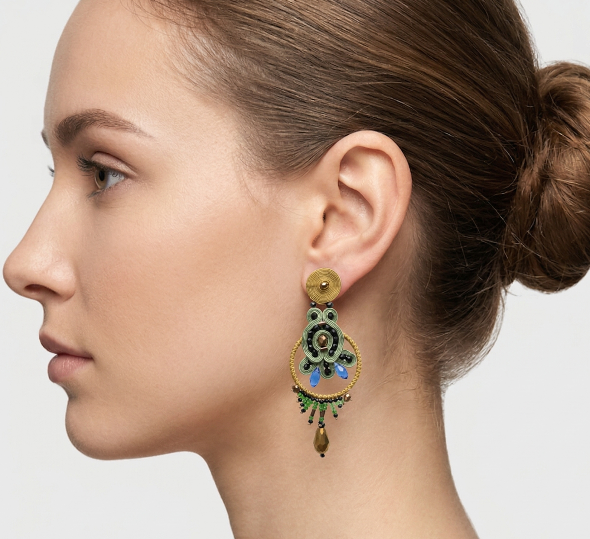 Mujer luciendo los pendientes statement Almona, destacando su tamaño y cómo el color verde ilumina el rostro.