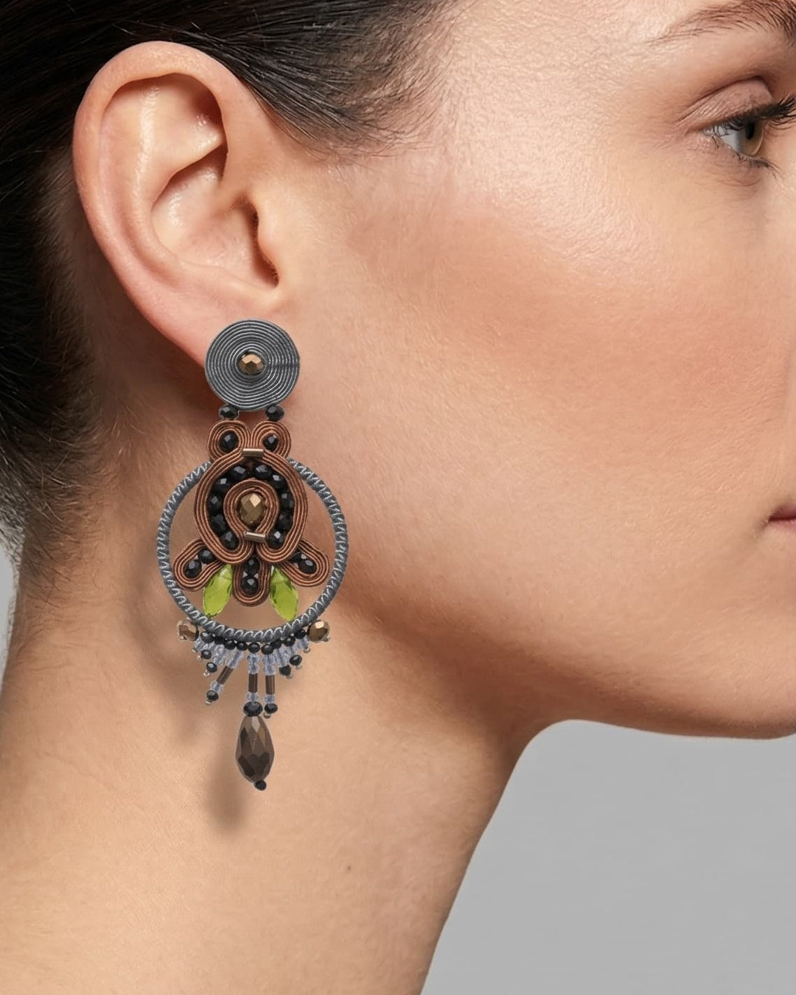 Primer plano de mujer luciendo pendientes largos artesanales de la marca Musula.