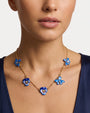 Modelo luciendo el collar corto de flor pensamiento azul de Les Néréides ajustado sobre la clavícula.