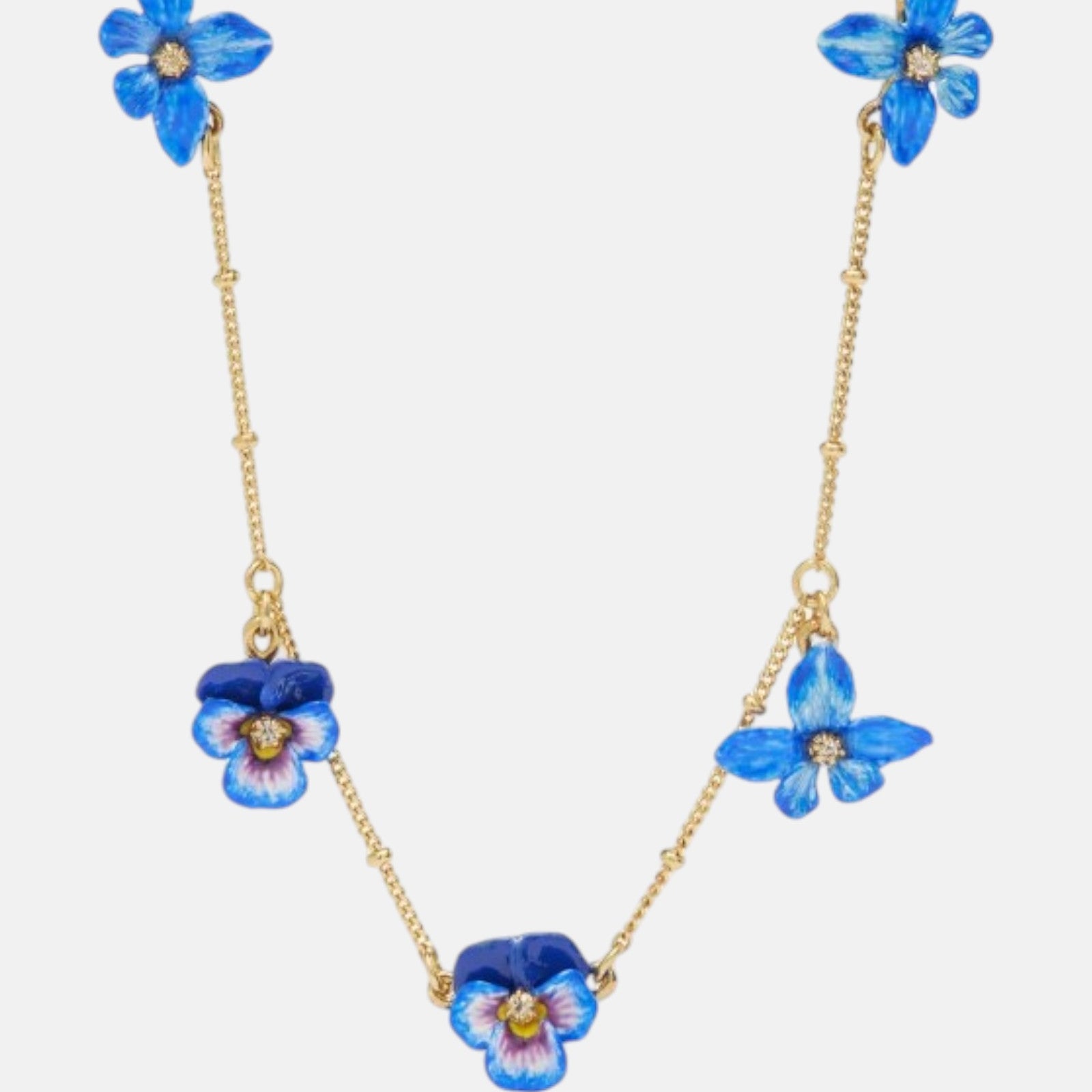 Collar fino de Les Néréides bañado en oro con colgante de flor pensamiento azul esmaltada y cristal facetado central.