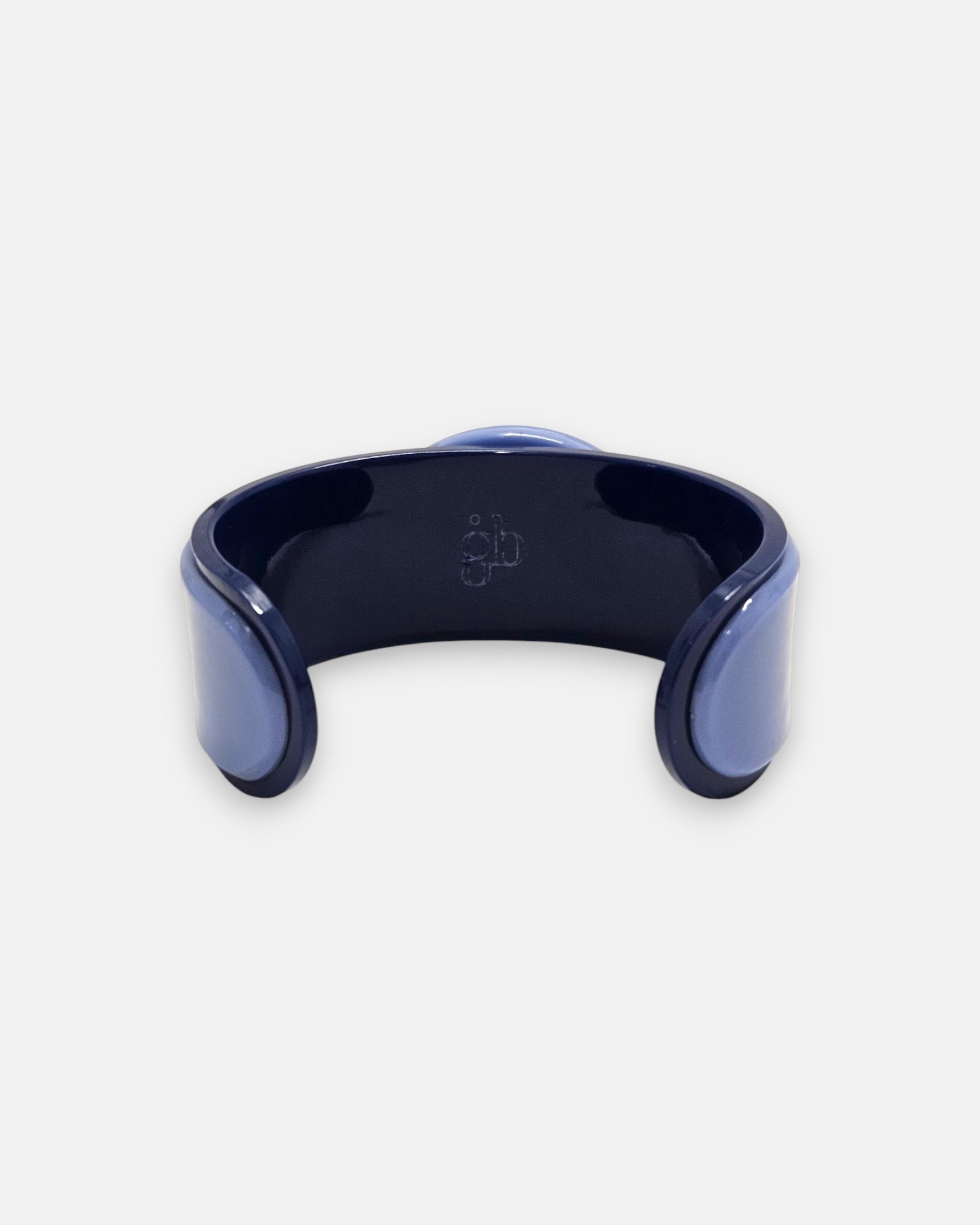 parte trasera abierta de la pulsera de Gissa Bicalho, revelando el interior de la estructura y el logotipo de la firma grabado en la pieza central.