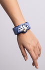 brazalete acrílico de Gissa Bicalho colocado en la muñeca de una modelo, destacando su escala, su acabado pulido brillante y su ajuste ergonómico.