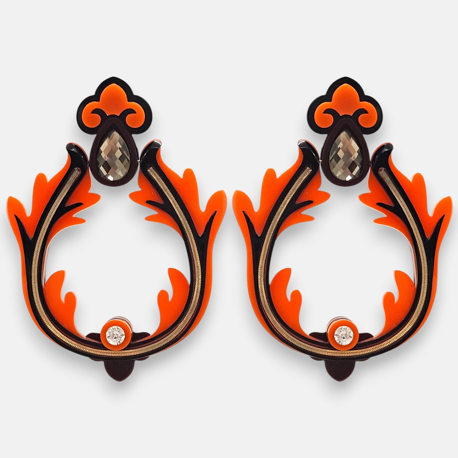 Pareja de pendientes grandes geométricos de Gissa Bicalho con forma de abanico en acrílico negro mate, veteado color café, crema nacarado y detalles de latón dorado.
