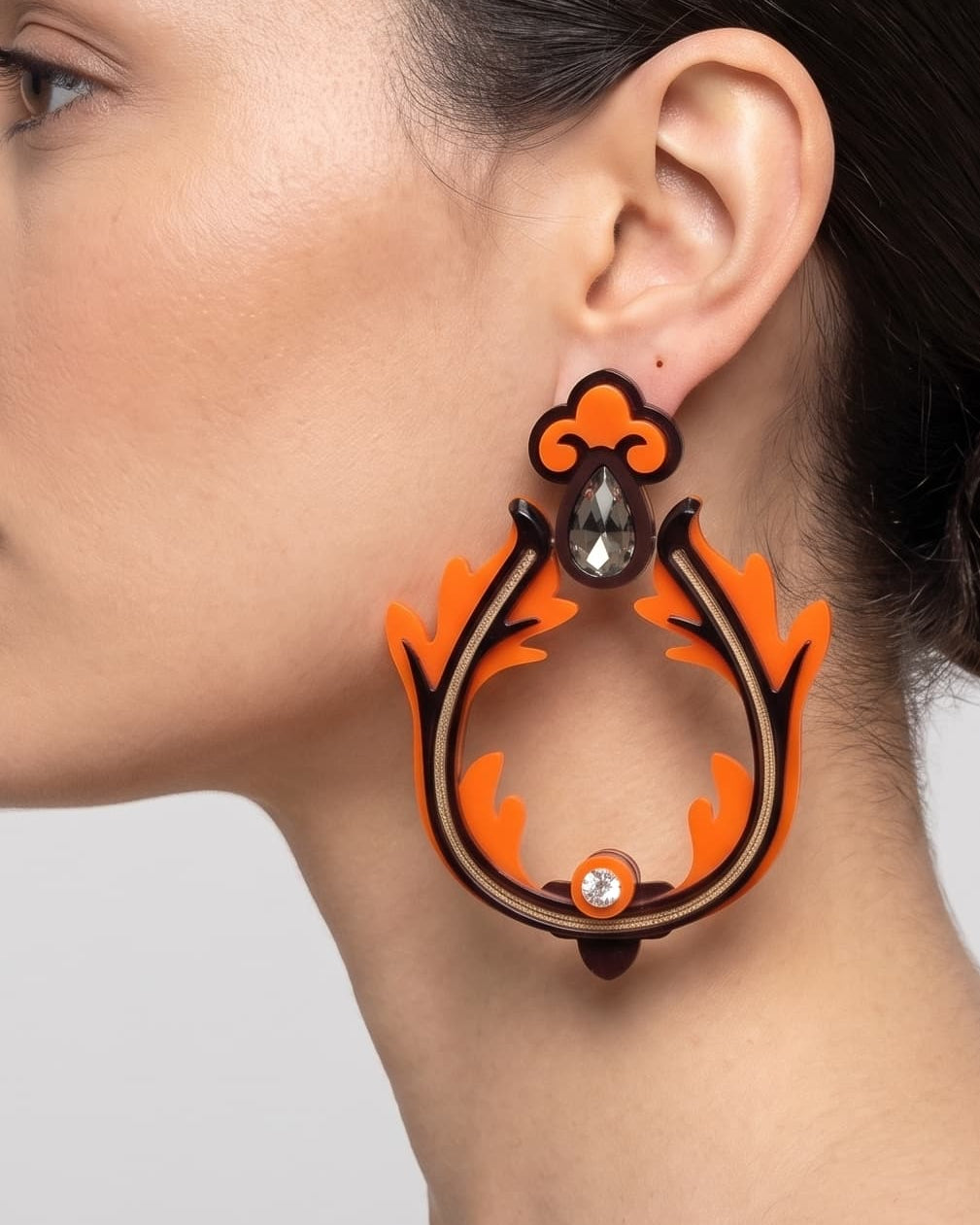 Vista frontal de los maxi pendientes escultóricos de Gissa Bicalho en una modelo, detallando su caída tridimensional de estilo arquitectónico y su gran escala.
