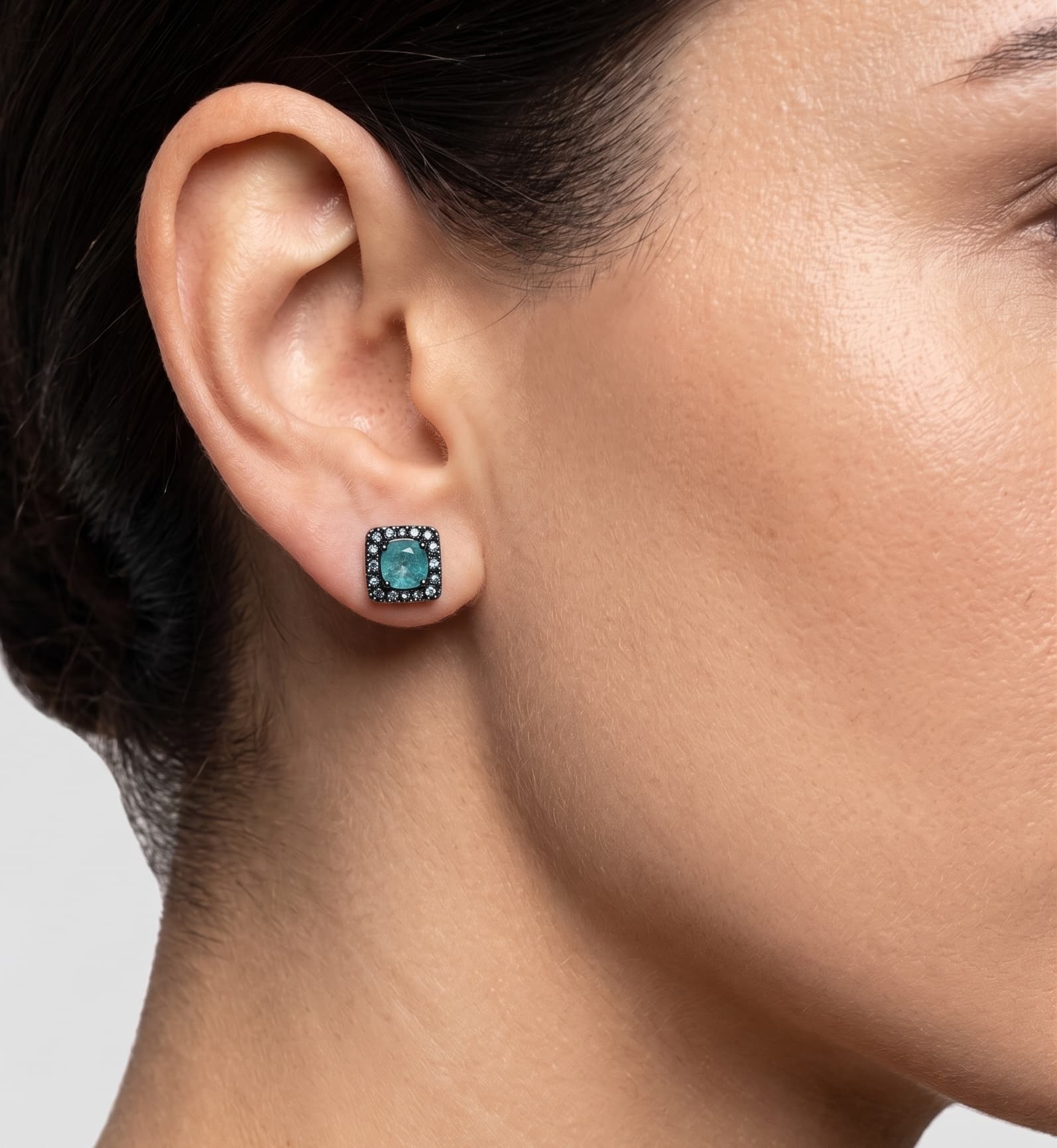 Mujer luciendo los pendientes Bohemme Aqua Square, resaltando el brillo de la gema turquesa y su tamaño proporcional al lóbulo.