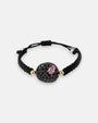 Pulsera de cordón negro Bohemme con medallón circular de espinelas negras y piedra central rosa.