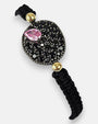 Primer plano del medallón de la pulsera Bohemme mostrando el contraste entre la piedra rosa, las espinelas y el oro de 18K.