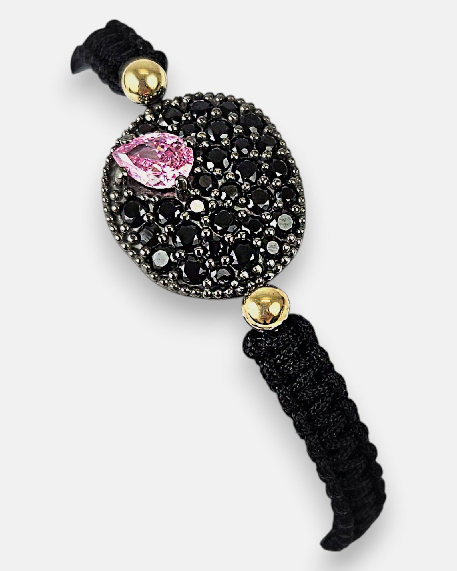 Primer plano del medallón de la pulsera Bohemme mostrando el contraste entre la piedra rosa, las espinelas y el oro de 18K.