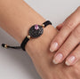 Mujer luciendo la pulsera ajustable Bohemme Night Blossom, resaltando el medallón de pavé y oro sobre la muñeca.