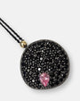 Primer plano del medallón Bohemme mostrando el pavé de espinelas, la piedra rosa y la unión en oro de 18K.