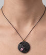 Mujer luciendo el colgante Bohemme Night Blossom, resaltando su brillo sobre la piel y su diseño elegante.