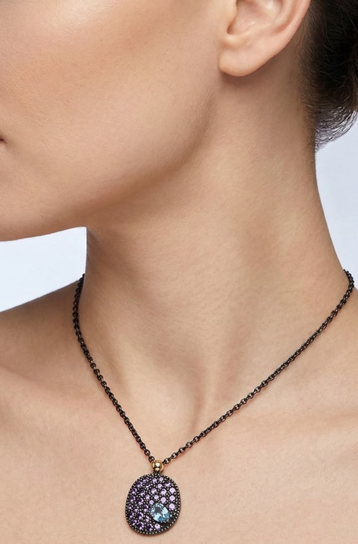 Mujer luciendo el collar corto Bohemme Musa violeta, destacando la elegancia del medallón sobre el escote.