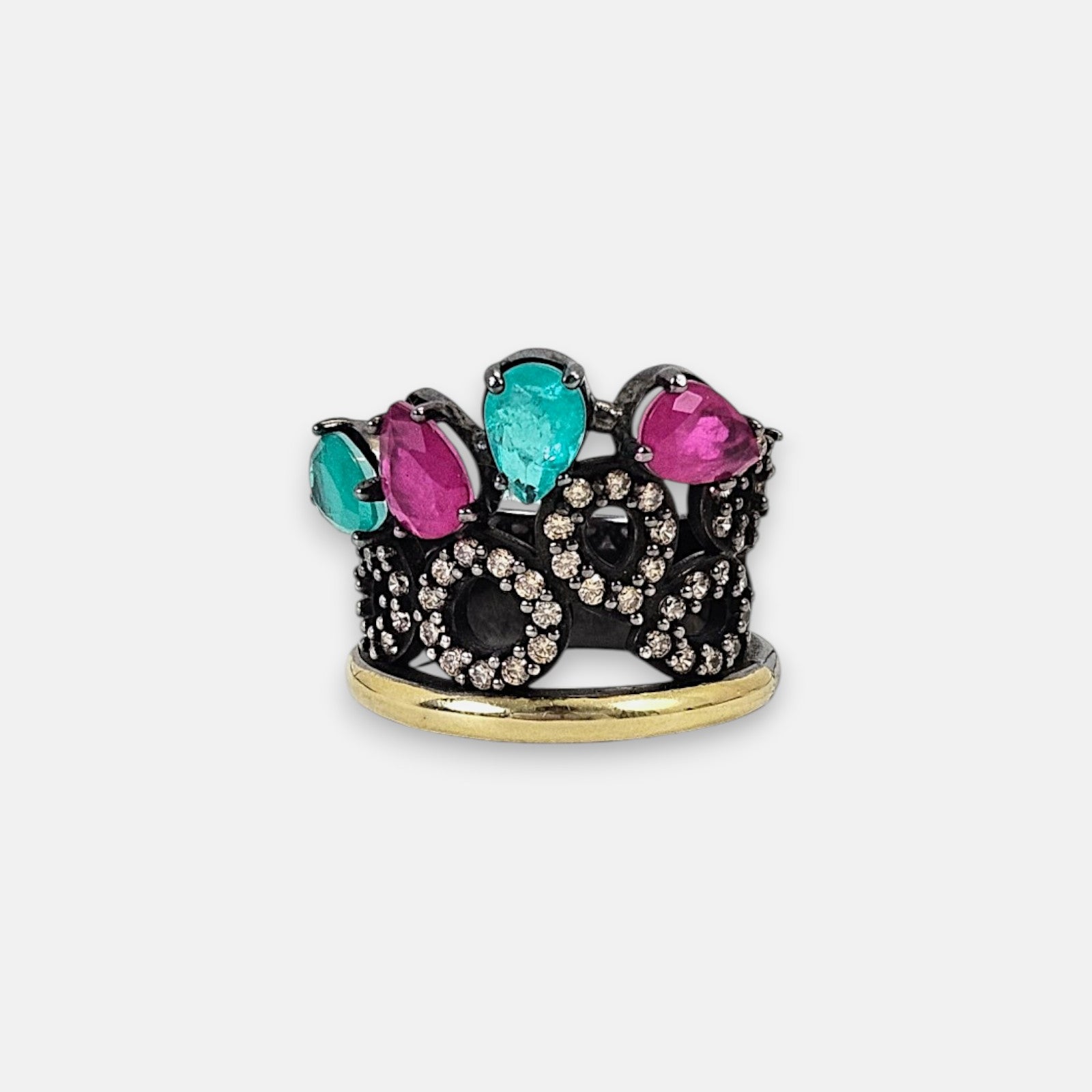 Anillo ancho Bohemme con diseño de corona en plata envejecida, detalle de oro y gemas rosas y verdes en talla pera.