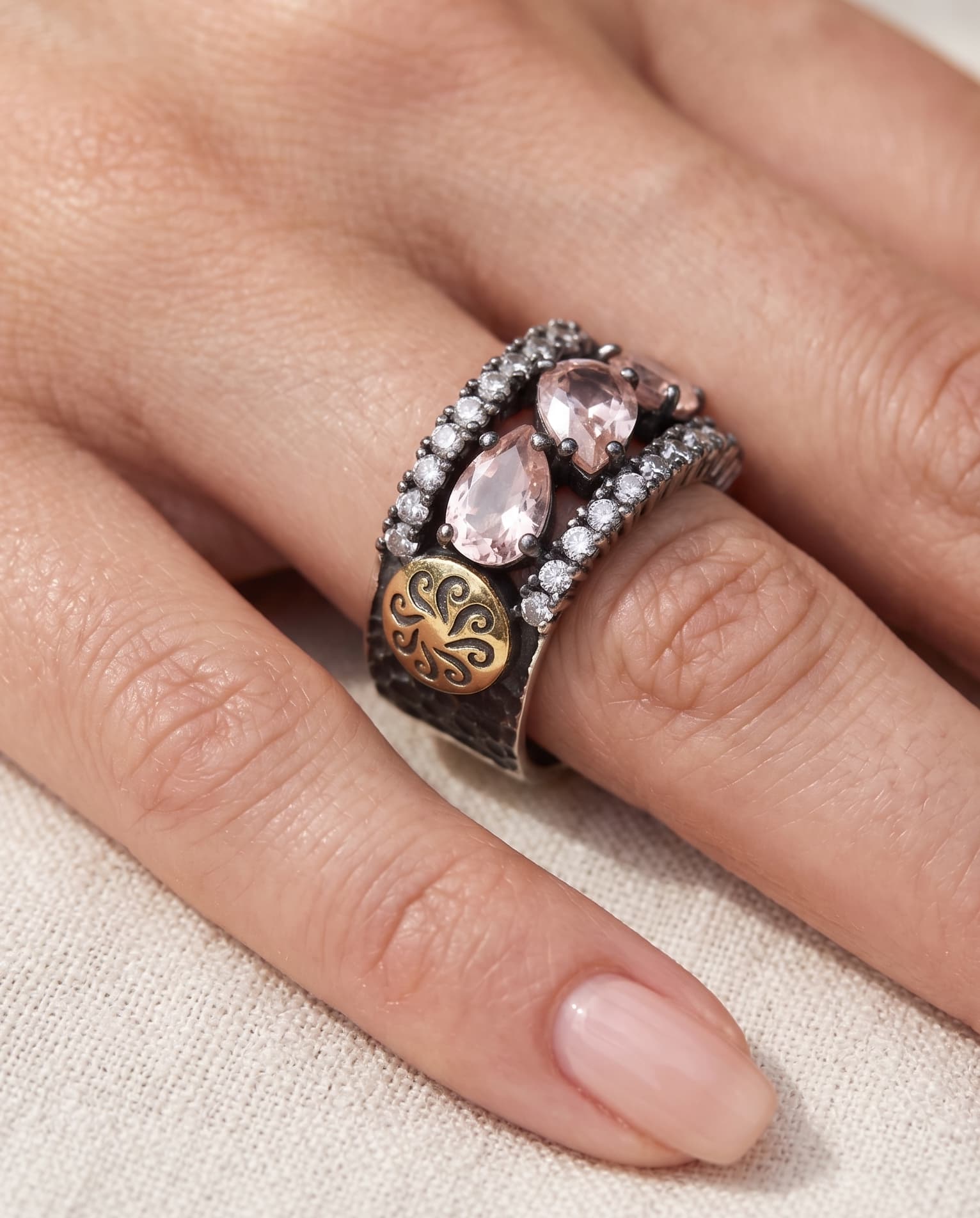 Mujer luciendo la sortija statement de Bohemme, destacando el medallón lateral de oro 18K.