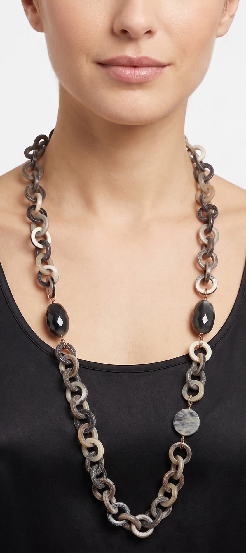 Mujer luciendo el collar largo Amlé, resaltando la elegante caída de los eslabones de cuerno sobre un top negro.