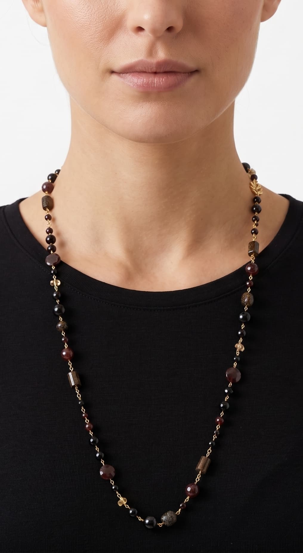Primer plano de mujer luciendo el collar largo Amlé, resaltando el diseño elegante y los tonos tierra sobre un top negro.