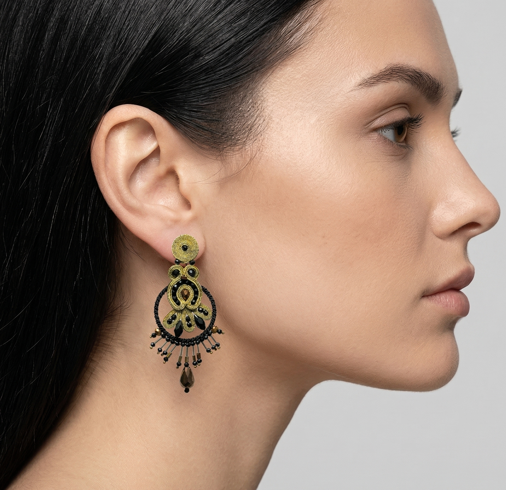 Mujer luciendo los pendientes Golden Opera, resaltando su tamaño y cómo enmarcan el rostro con elegancia nocturna.