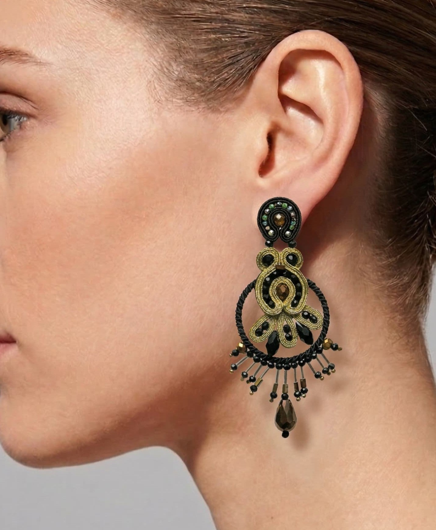 Mujer luciendo los pendientes Golden Opera, resaltando su tamaño y cómo enmarcan el rostro con elegancia nocturna.