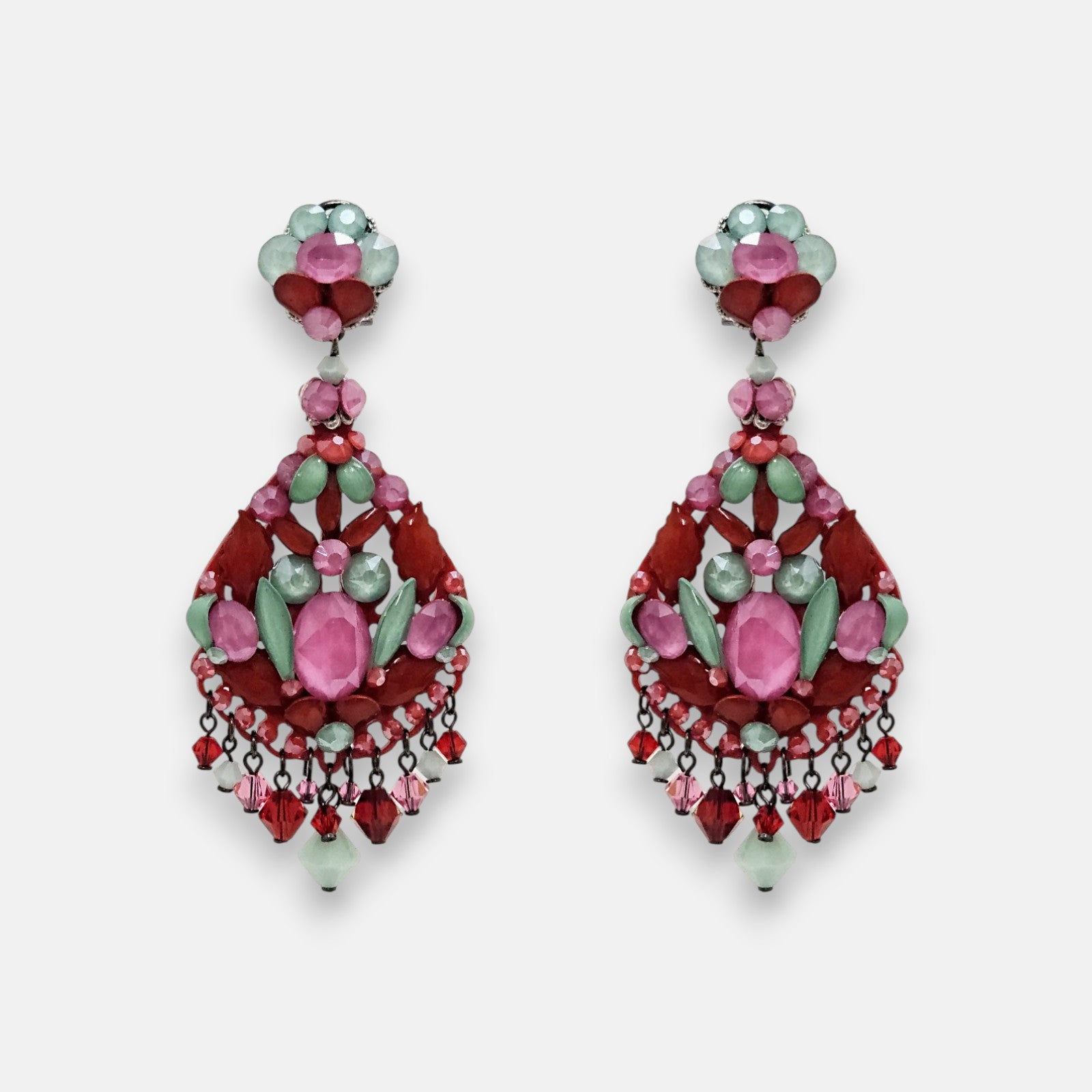 Par de pendientes largos Dublos tipo chandelier con cristales en tonos rosa y verde sobre fondo neutro.