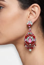 Primer plano de perfil de mujer luciendo los pendientes largos Dublos, resaltando el contraste de los cristales rosas y verdes.