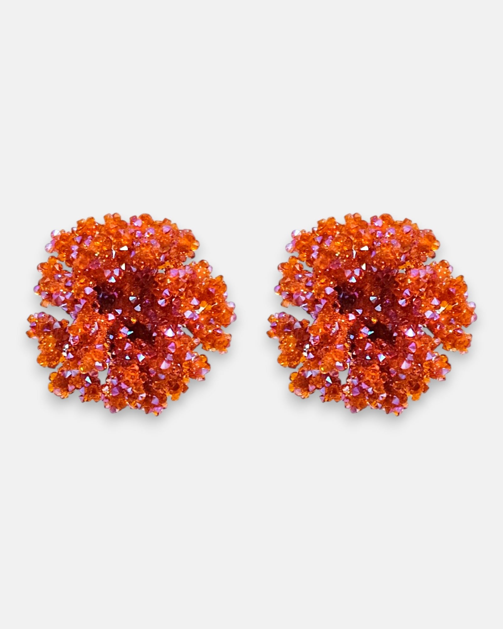 Pareja de pendientes de botón redondos en color naranja mandarina de la firma Dublos, mostrando su textura esférica y el brillo de sus cristales iridiscentes.