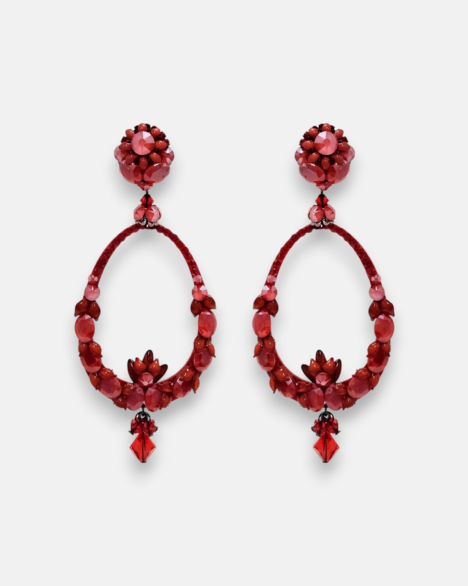 Par de pendientes de aro estilo gota Dublos en tonos rojos con cristales tallados sobre fondo neutro.
