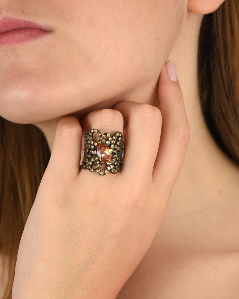 Mujer luciendo el anillo maxi Hechizo de Bohemme, resaltando su diseño barroco y el brillo de las gemas champagne.