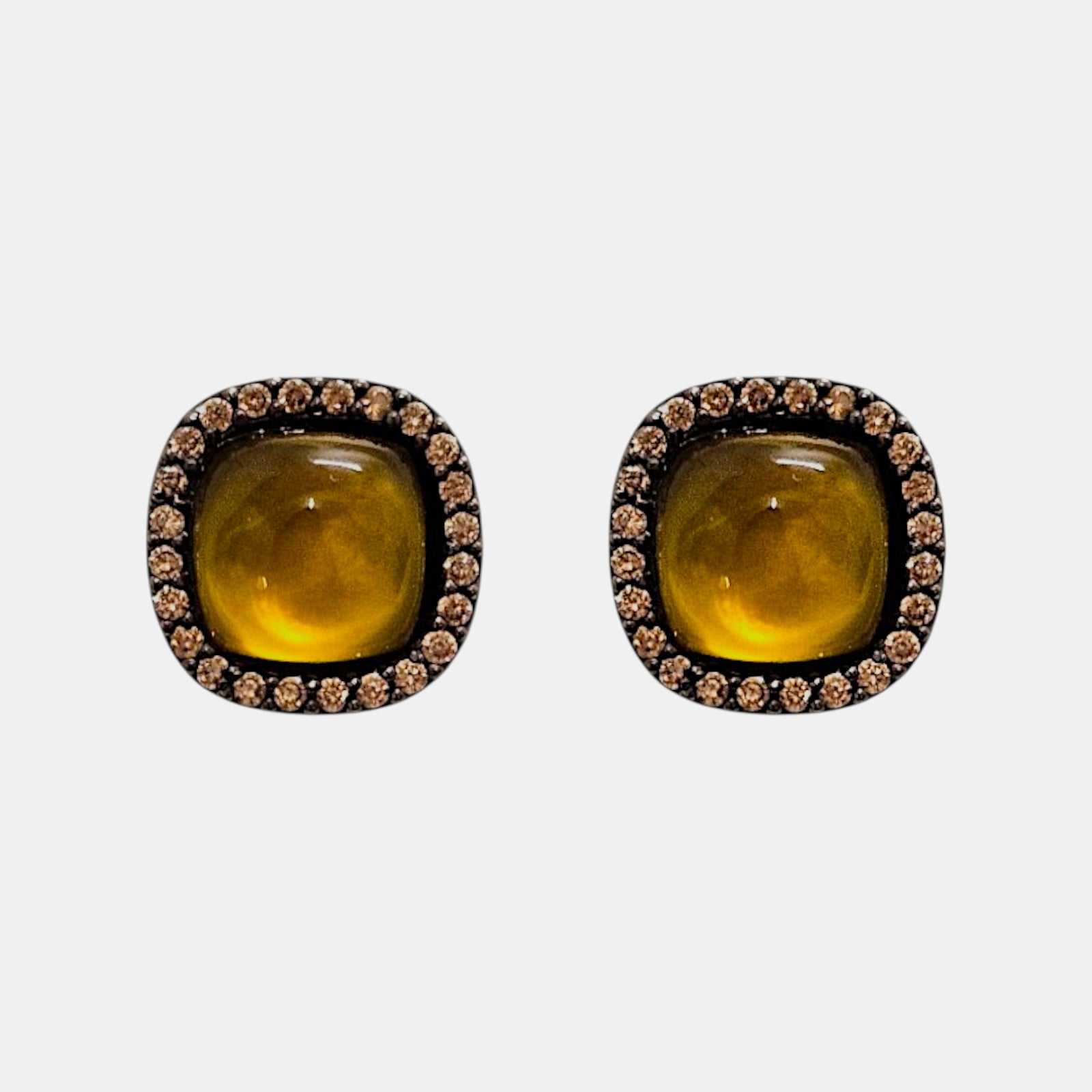 Pareja de pendientes de botón Bohemme con cabujón central color miel y orla de circonitas sobre plata oxidada.