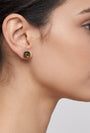 Mujer luciendo los pendientes Bohemme Amber Halo, destacando el brillo cálido de la gema ambarina en el lóbulo.