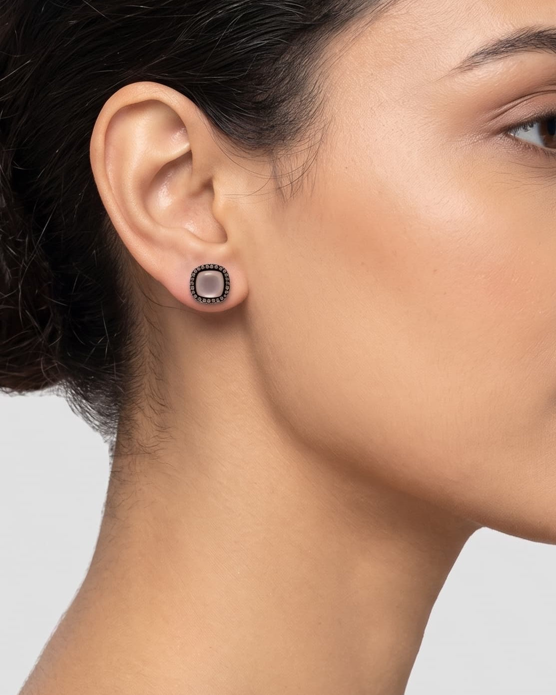 Mujer luciendo los pendientes de botón en cuarzo rosa de Bohemme, resaltando su tono suave y diseño elegante.