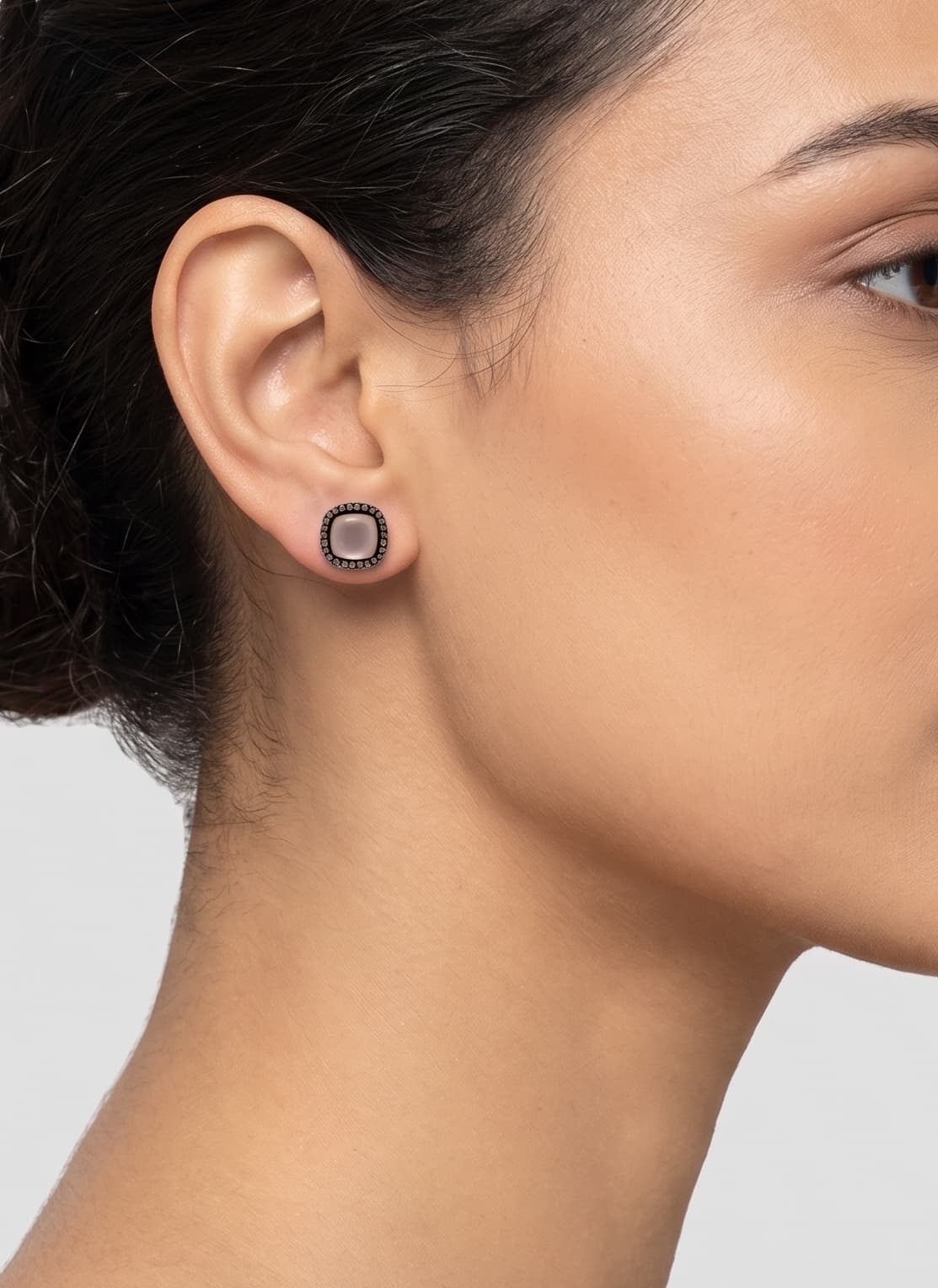 Mujer luciendo los pendientes de botón en cuarzo rosa de Bohemme, resaltando su tono suave y diseño elegante.