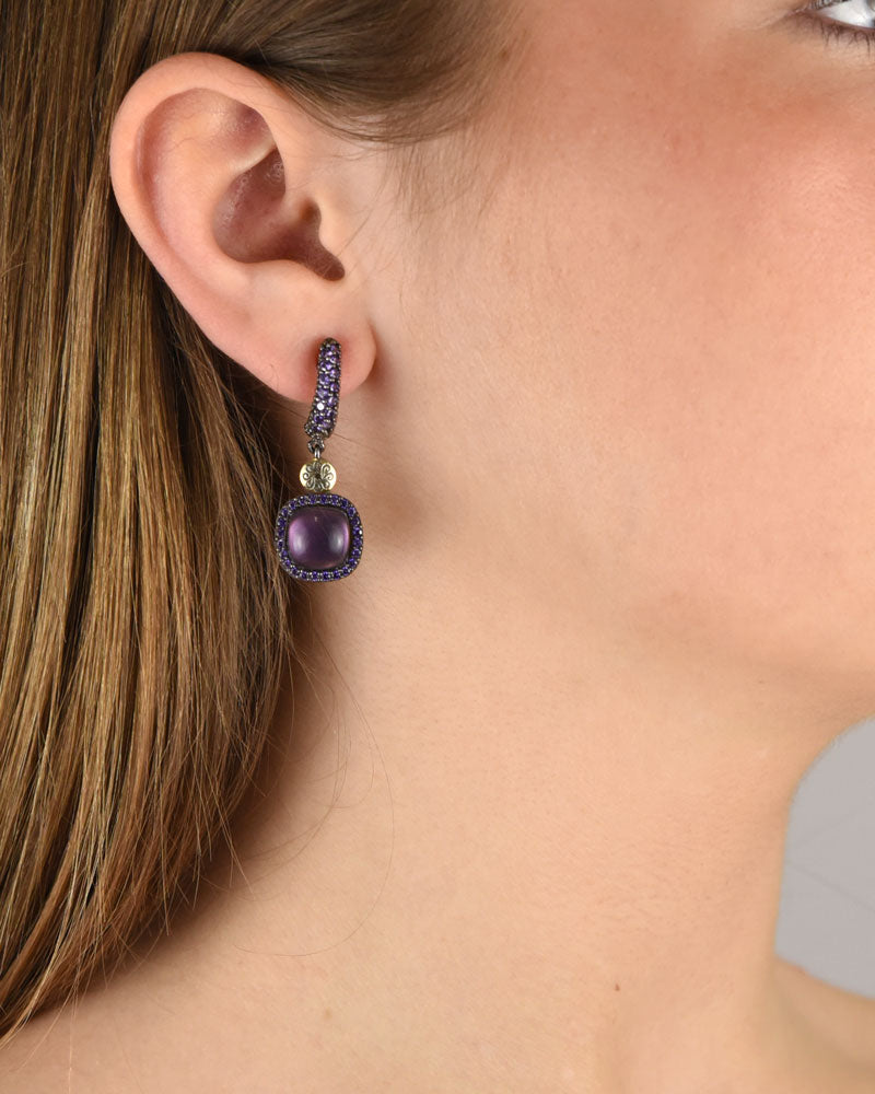 Mujer luciendo los pendientes de gota con amatista violeta de Bohemme, destacando su elegancia y misterio cromático.