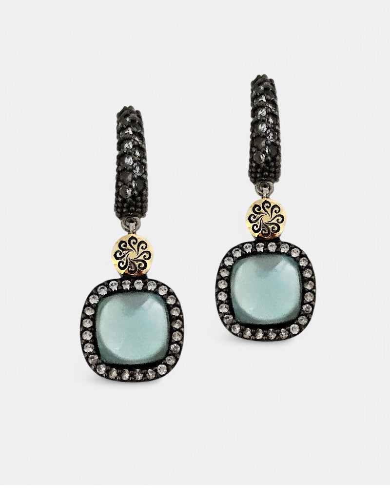 Pareja de pendientes Bohemme Hechizo con piedra central azul cabujón, pavé de circonitas y detalle en oro.