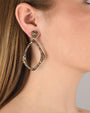 Mujer luciendo los pendientes Bohemme Musa statement, resaltando su tamaño y el brillo de las circonitas de colores.
