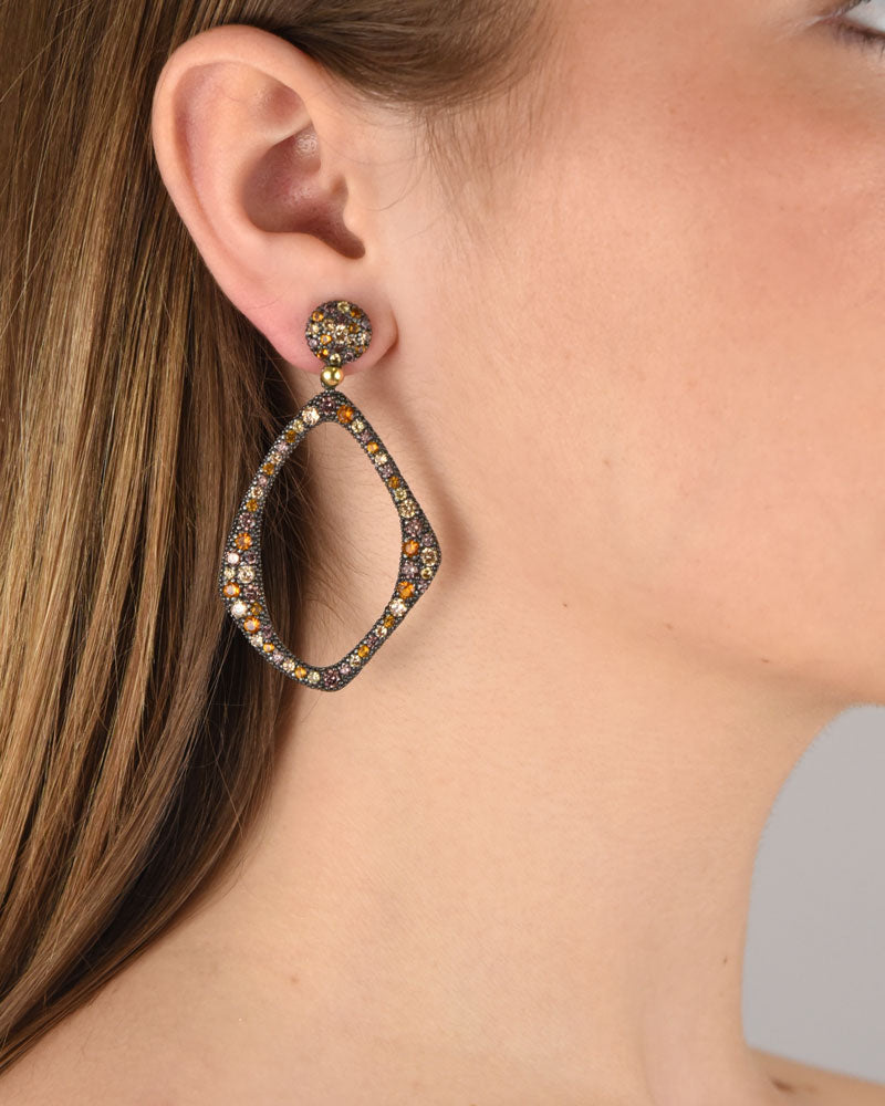Mujer luciendo los pendientes Bohemme Musa statement, resaltando su tamaño y el brillo de las circonitas de colores.