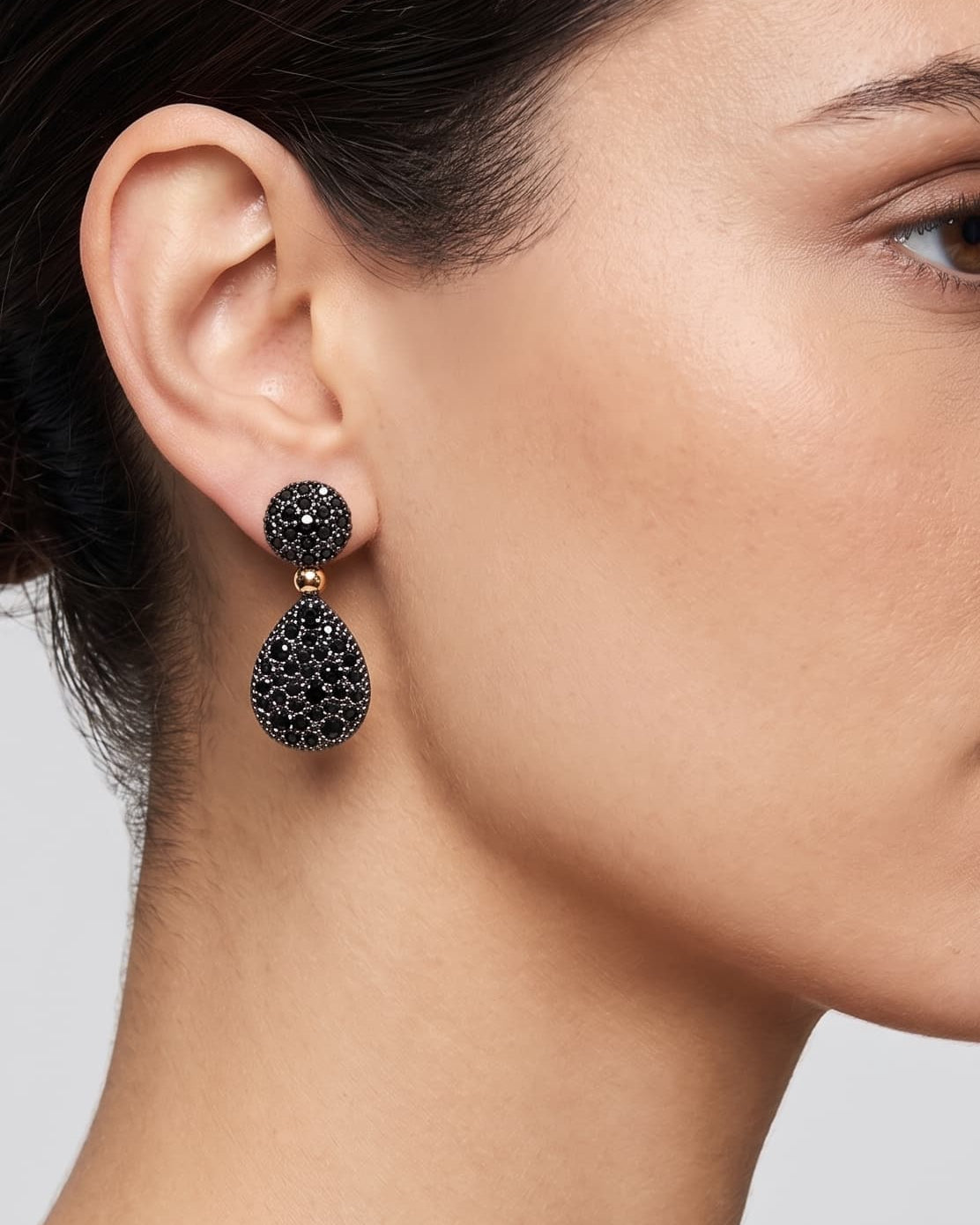 Mujer luciendo los pendientes de lágrima negros de Bohemme, resaltando su brillo profundo y movimiento elegante.